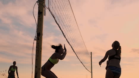 Sexy-volleyball-girls-in-bikini-play-on-the-beach-in-summer-volleyball-on-the-sand-at-sunset-in-slow-motion